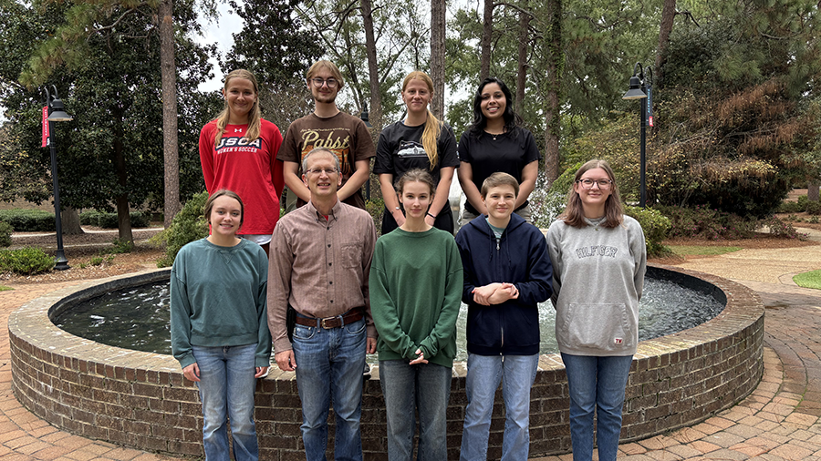 Student pose for a group photo with faculty mentor, Nathan Hancock